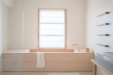 a minimalist bathroom with white walls and wood clad tub
