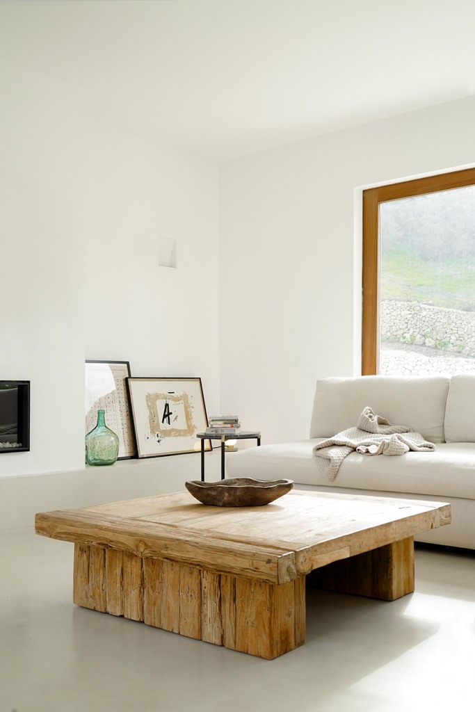 The living room features a wooden table, some artworks and a comfy sofa and cool views