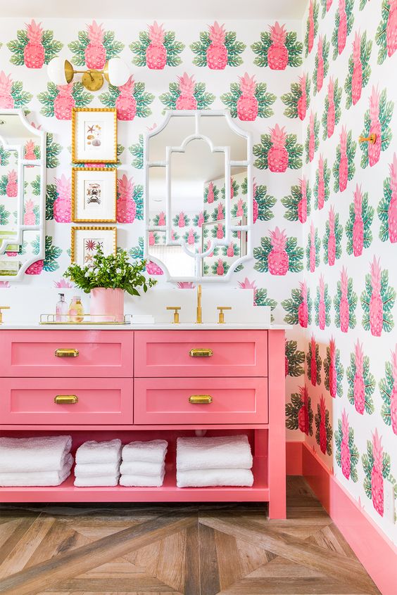 the whimsical pineapple wallpaper and bright pink color scheme in this bathroom screams Palm Beach