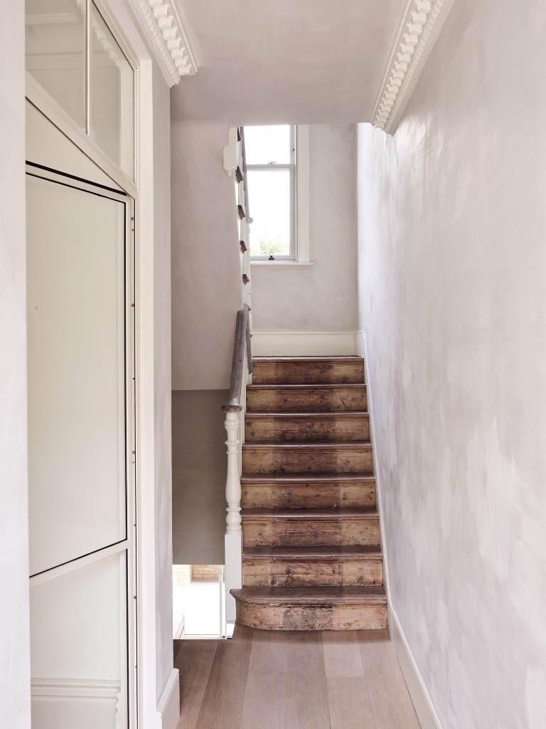 The staircase is dark stained to make a contrast to the white walls and add texture