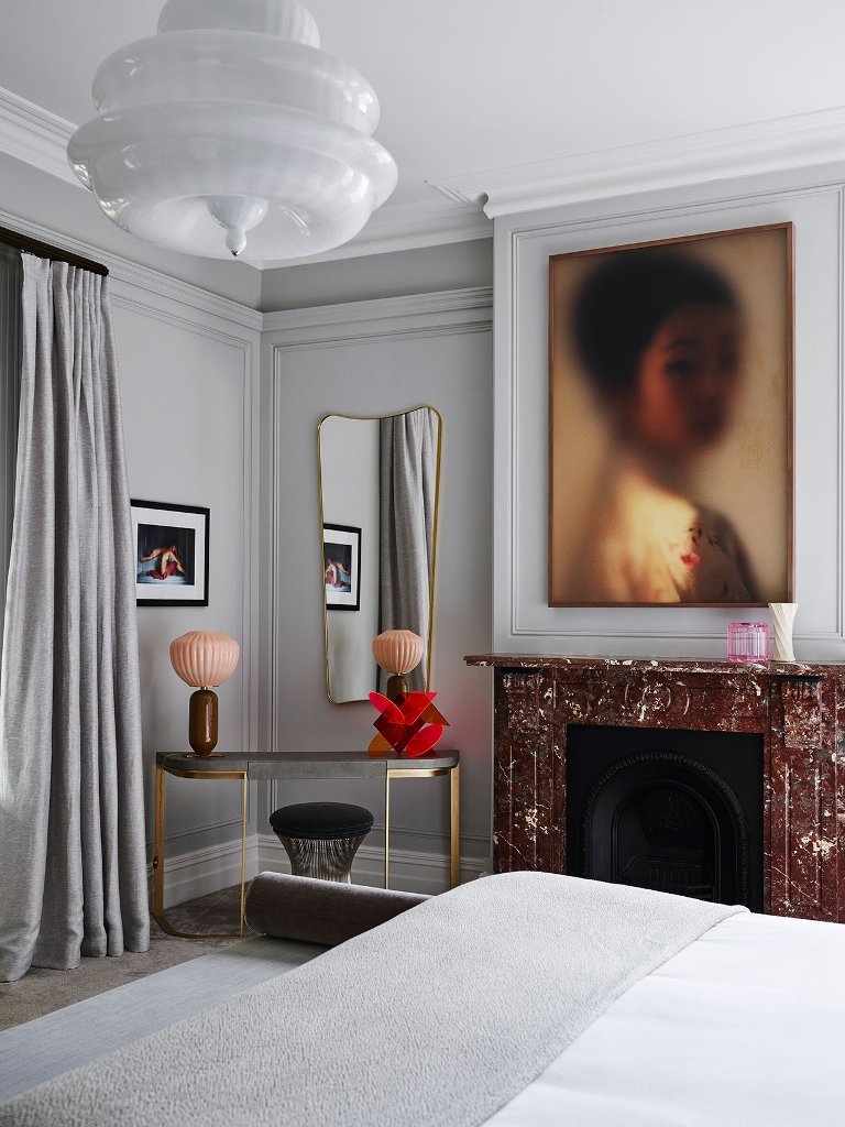 The bedroom can boast of a lovely stone clad fireplace and a muted artwork