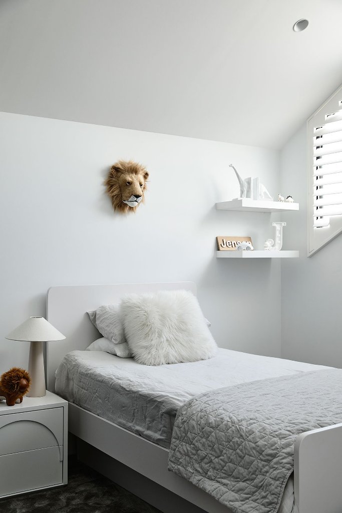The kid's room is all white and off white, with some furniture and a touch of fun