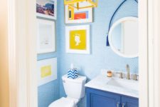 12 a bold powder room with blue penny tiles, a blue vanity, a yellow lantern and a pretty and bright gallery wall