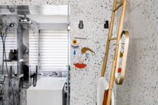 13 The master bathroom is done with terrazzo and grey marble tiles, with modern fixtures and touches of gold