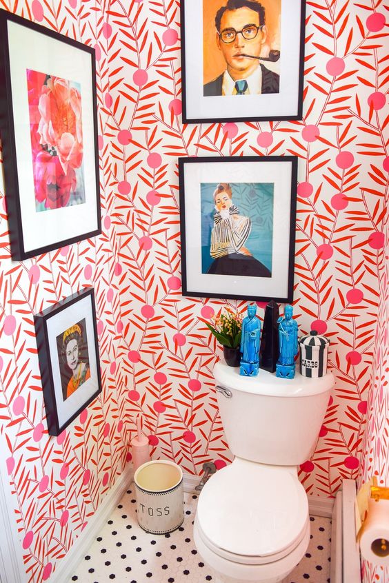 a colorful powder room with bold wallpaper and statement artworks plus statuettes is all about fun