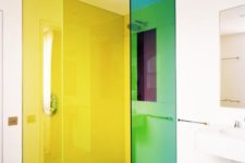 26 a white bathroom with green and yellow florescent glass shower doors that take over this space