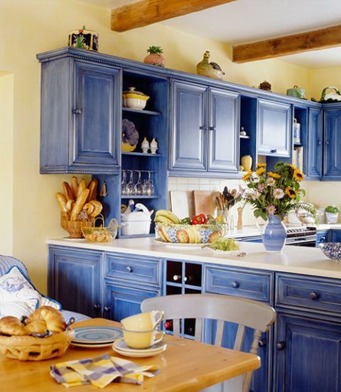 a bright blue and light yellow kitchen refreshed with white surfaces and with light-colored natural wood
