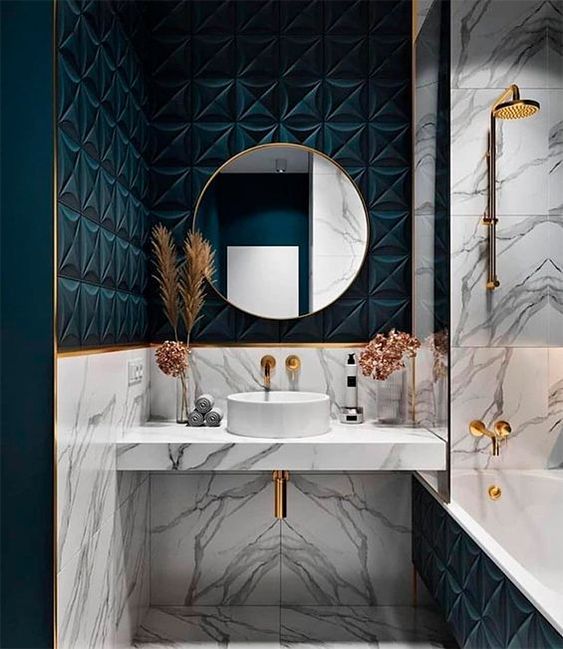 a chic bathroom with white marble and teal tiles, with gold accents and edges here and there for a refined touch