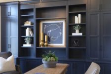 a farmhouse home office with navy walls – one of them taken by a storage unit, neutral furniture and gold touches for more elegance