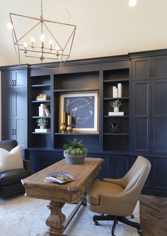a farmhouse home office with navy walls - one of them taken by a storage unit, neutral furniture and gold touches for more elegance