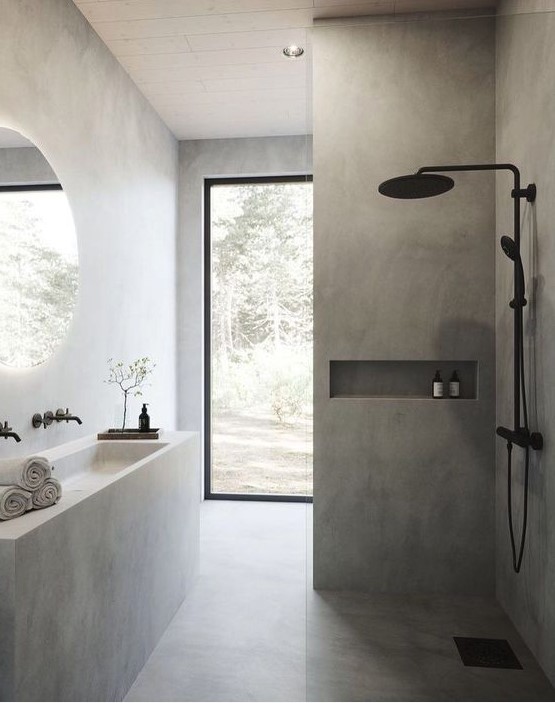 A minimalist concrete bathroom with a built in vanity and a sink, a shower space, a glazed wall and black fixtures