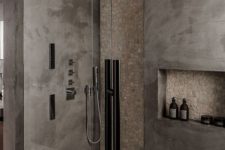 a minimalist grey and taupe bathroom done with concrete and stone, with a wooden rug and black touches