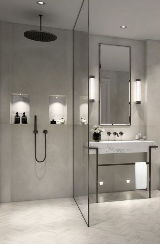 a minimalist grey bathroom done with various tiles, with a marble vanity and black framing and fixtures for a bolder look