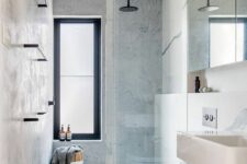 a minimalsit grey bathroom with grey walls and dark grey large scale tiles, a sink, a shower space and a mirror cabinet