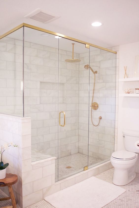 a modern glam white bathroom with a shower, gold fixtures, white appliances, white textiles is lovely