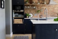 a navy kitchen with white countertops for a refresh and a brick wall in warm shades for a texture and a softer look