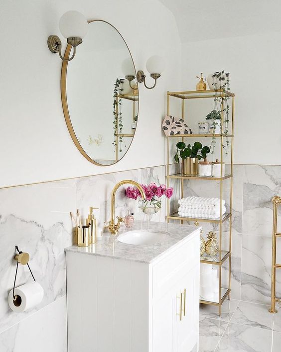 a neutral bathroom with a tall gold etagere, a matching stand and a cool sign on the wall