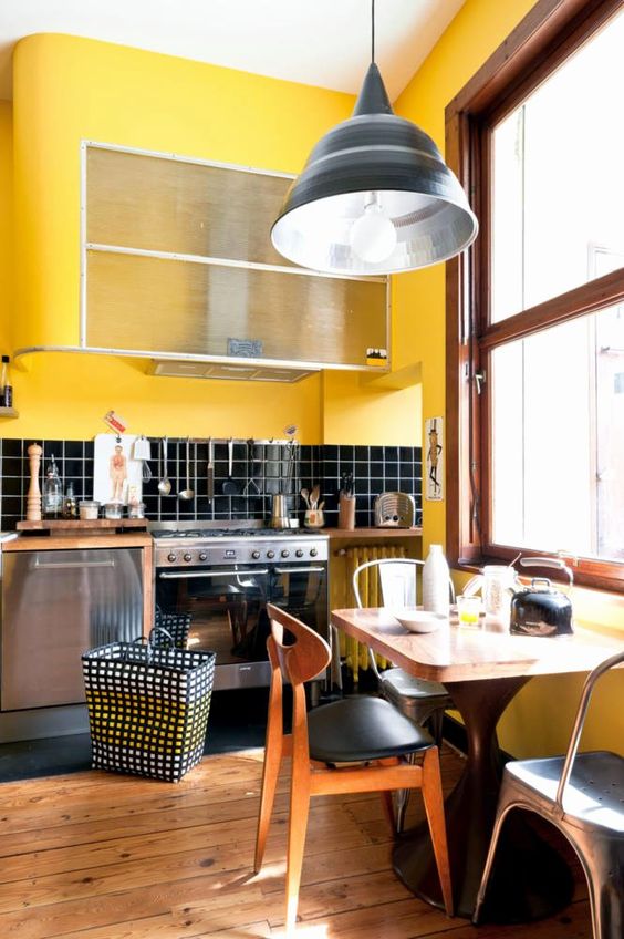A retro kitchen done in bright yellow and black, with chic mid century modern furniture and touches of warm stained wood
