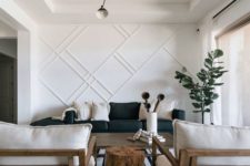 a stylish living room with a white paneled wall that makes an accent and looks bold adding style and chic to the space