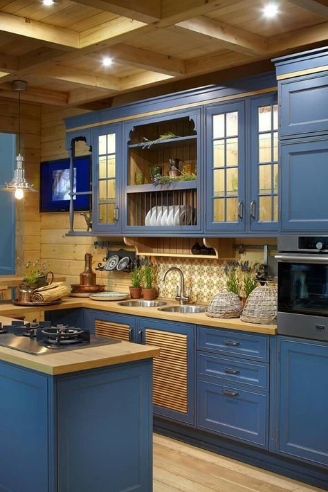 a stylish vintage farmhouse kitchen with blue cabinets and buttercream yellow wooden countertops and backsplashes