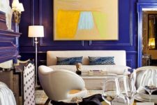 a super bold, whimsy and luxurious living room with bold blue paneled walls that make a color statement at once