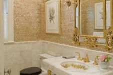 a super glam powder room with gold shingle walls, a refined mirror, a vanity with gold legs and a crystal chandelier