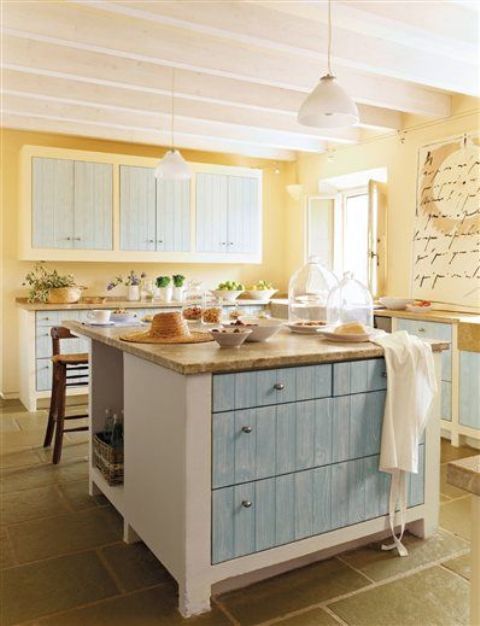 a unique vintage kitchen with light yellow walls, light blue cabinets and pendant lamps plus wooden surfaces