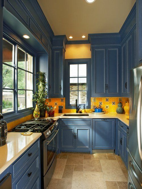 a vintage blue and bright yellow kitchen with a mosaic tile backsplash and built-in lights looks chic and elegant