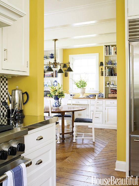 a vintage kitchen with sunny yellow walls, white cabinetry, black and navy touches for a bright contrast and bold looks