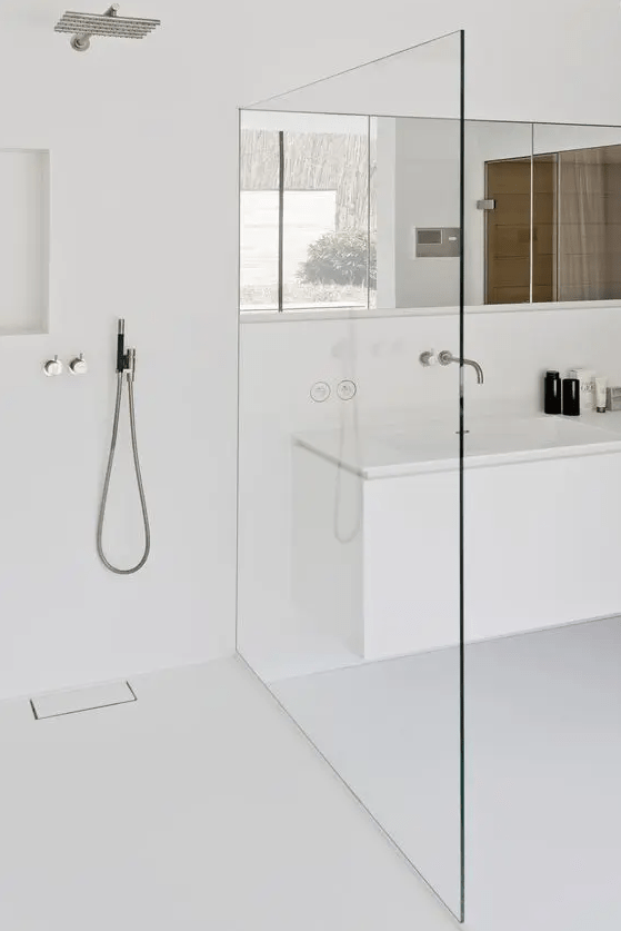 an ultra-minimalist white bathroom with a seamless shower, a long mirror and clean lines