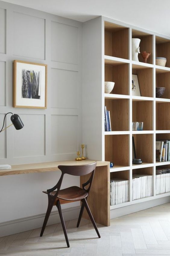 Make a usual neutral wall chic and catchy with paneling like here and it will echo with built in shelves