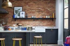 navy grey cabinetry, white countertops, a brick wall and a skylight to refresh the space