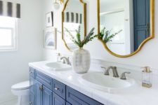 white as the main color, a bold blue vanity, gold fixtures, catchy mirrors in gold frames for a super chic look
