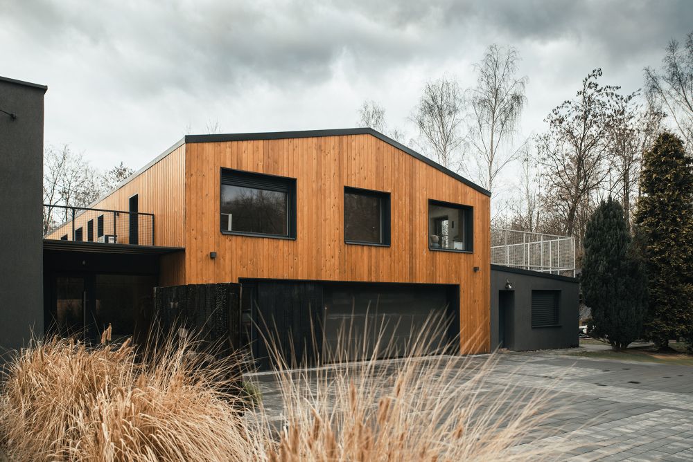 This modern barn home was built using the remnants of the 70s structure and looks bold and contrasting