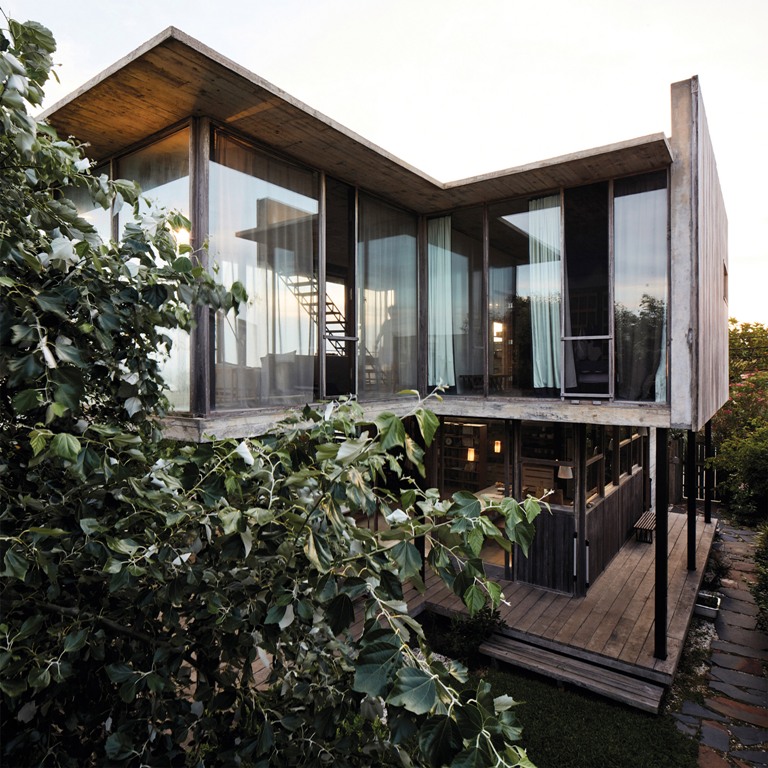 The house features much weathered wood and concrete, and it opened to outdoors