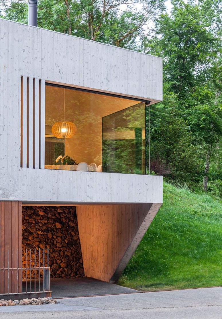 The house is clad with light-colored wood, there are glazed walls that allow enjoying the views