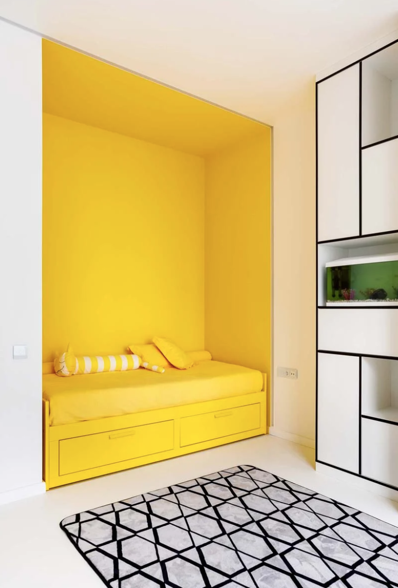The kid's room shows off graphic decor, a black and white color scheme and colorful accents - a yellow bed niche and a green touch