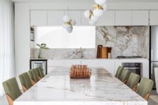 03 The kitchen is done with minimalist white cabinets, a marble backsplash, the dining space is next to it echoing the design with a fabulous marble dining table