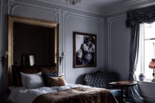 04 a refined moody bedroom with a statement mirror in a simple frame and a chic chandelier that make the space wow