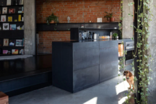 a kitchen with dark furniture and brick walls