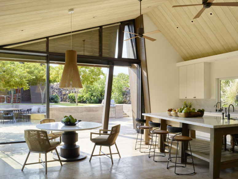 The kitchen is all-neutral, and there's a small dining zone with a wooden pendant lamp