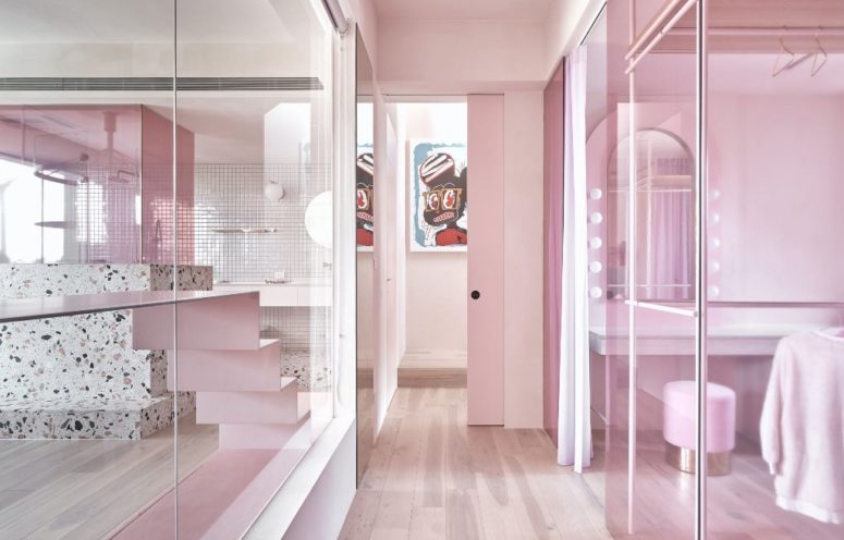Some spaces are divided only with glass partitions in pink to connect them and brign more light here