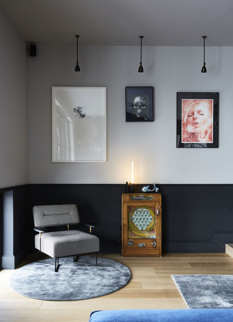 This nook features a unique gallery wall, pendant lamps, a little side table and a chic mid century modern chair