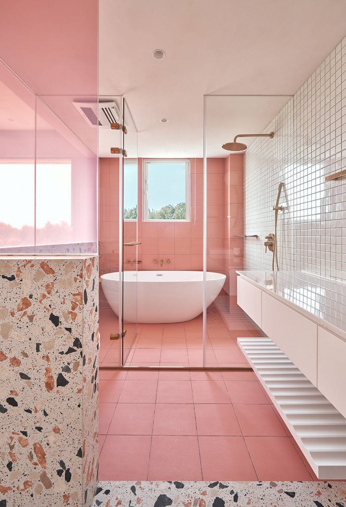 The bathroom also features lots of pink, neutral tiles and terrazzo