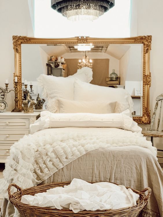 a gorgeous statement mirror in a refined gold frame is a nice alternative to a headboard that will enlarge the space