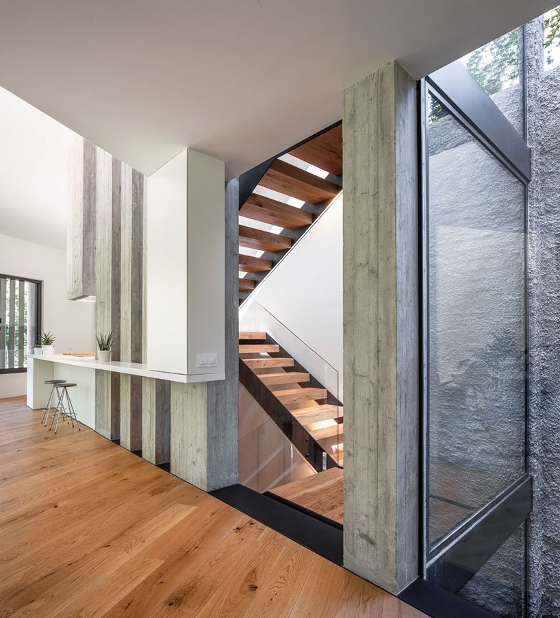 The staircase space features glass walls to fill the space with light and make it more airy