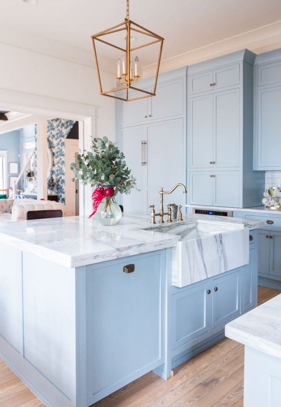 a beautiful and elegant light blue kitchen with white marble countertops that make a luxurious statement accenting the colors