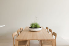 09 It features only a chic wooden dining set and a potted grass centerpiece