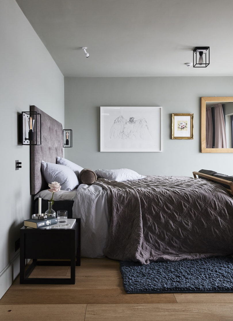 The master bedroom is very soothing, with grey walls, a gallery wall, dusty pink textiles and touches of black