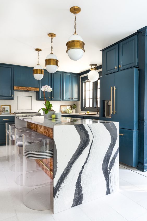 a chic blue kitchen and a kitchen island with a gorgeous white marble waterfall countertop that makes a statement here